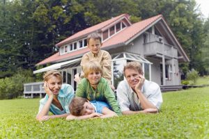 Familie vor ihrem Ferienhaus - Versicherungsschutz bei Vermietung