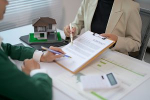 Immobilienmakler bespricht Hausbewertung und Vertrag mit Ferienhaus-Eigentuemer