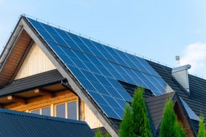 Photovoltaik-Solaranlage auf dem Dach eines Ferienhauses mit schwarzen Dachziegeln